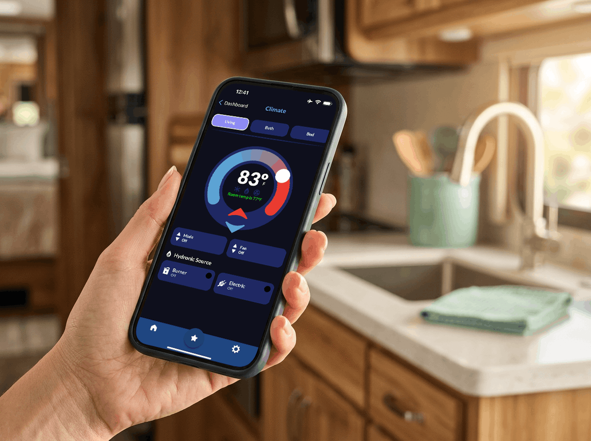 A hand holding a phone inside of a warm RV interior