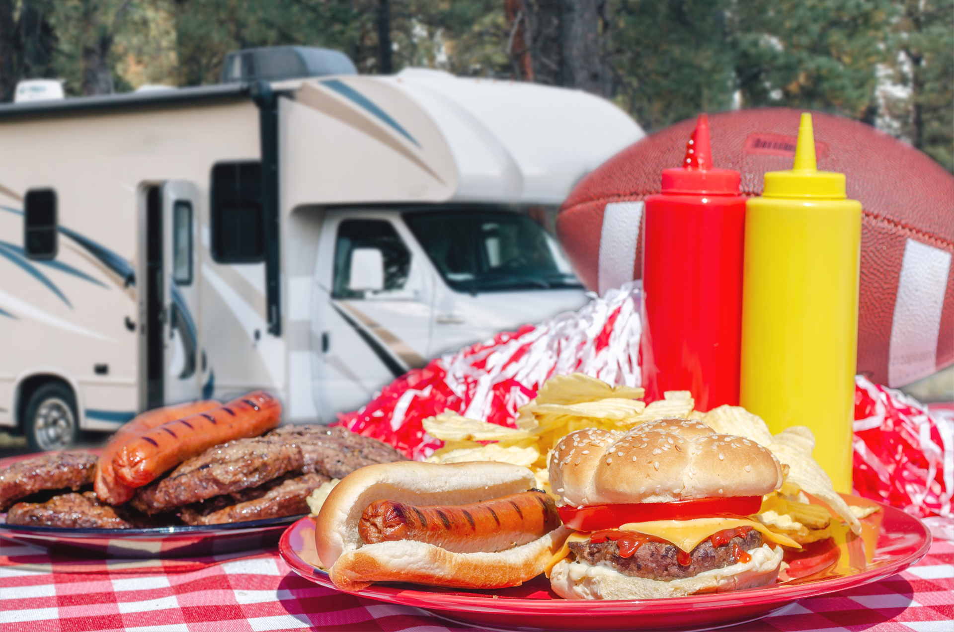 table with hotdogs and hamburgers in front of an RV