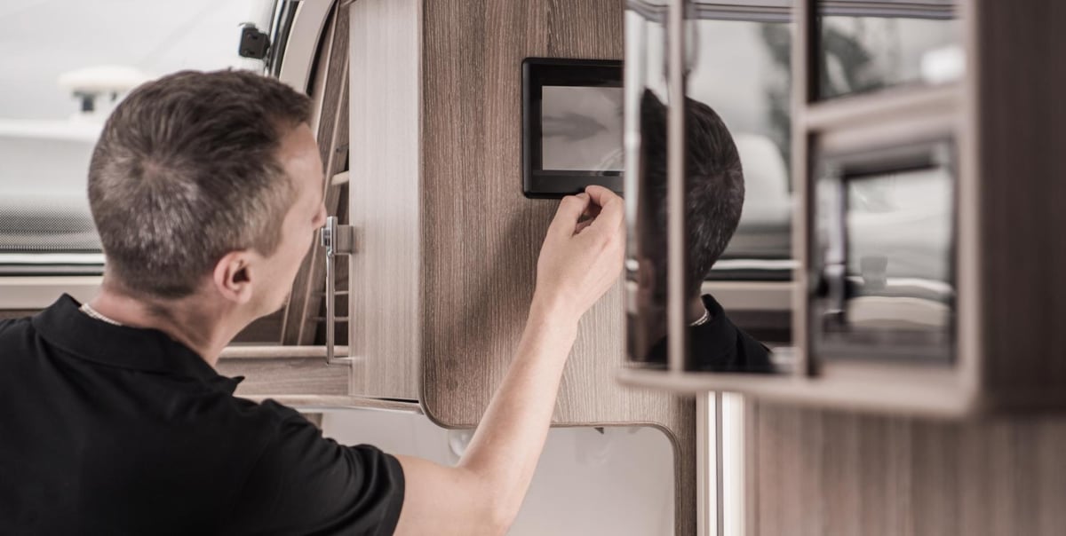 Man turning on LCD touchscreen in an RV